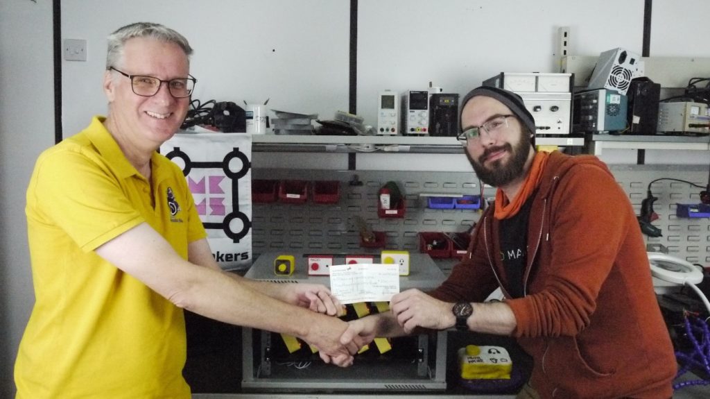 Phil Yates, Chair at MK Hospital Radio handing a cheque to Allan Gallup from MK Maker Space
